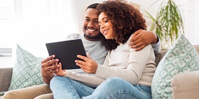 Couple dans son canapé qui regarde du contenu sur une tablette